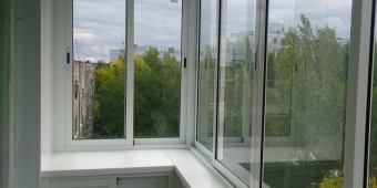 Холодное остекление Г - образного балкона с обшивкой пластиковыми панелями.